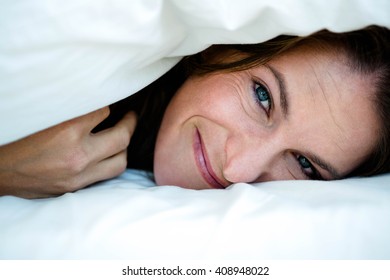 Smiling Woman With A Duvet Pulled Over Her Head