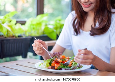 The Smiling Woman Enjoys Eating A Salmon Salad. To Lose Weight And Diet, Eat Foods That Are Beneficial To The Body. Weight Loss Concept.