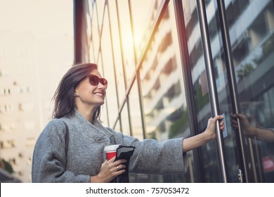 Smiling Woman Entering In The Building. Happy Businesswoman Getting To Work And Entering In Office Building.