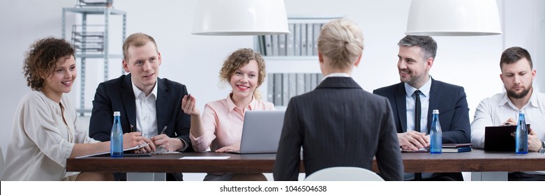 Smiling Woman From Examining Commission Asking A Question During Student's Defense Of Thesis