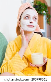 Smiling Woman With Face Pack Relaxing On Sofa Indoors
