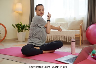 Smiling Woman Following Online Fitness Instructor When Stretching Arms