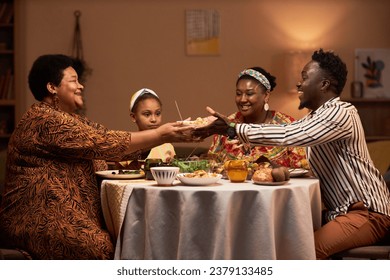 Smiling woman giving bowl of salad to her son-in-law to family dinner - Powered by Shutterstock