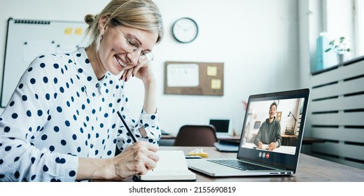 Smiling woman with googles has video call conference with her remote teammate. Laptop with camera teamwork