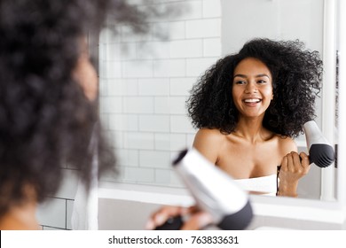 Smiling Woman With Hair Dryer Looking At Mirror