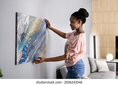 Smiling Woman Hanging Painting Or Picture Indoors