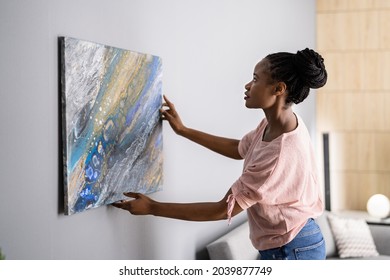 Smiling Woman Hanging Painting Or Picture Indoors