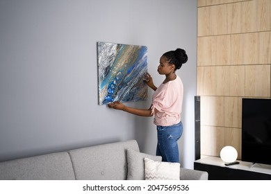 Smiling Woman Hanging Painting Or Picture Indoors