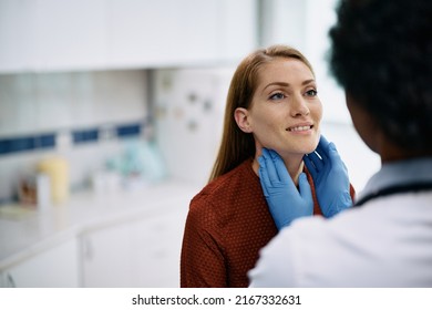 Smiling Woman Having A Thyroid Exam By Endocrinologist At Medical Clinic.