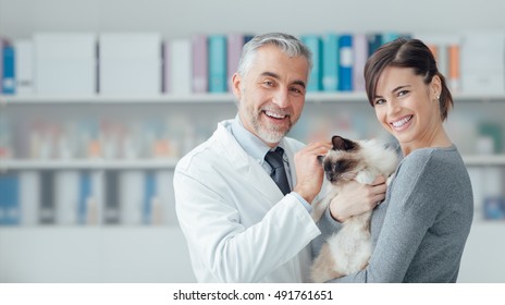 Smiling Woman And Her Cat At The Veterinary Clinic, A Doctor Is Cuddling Her Pet