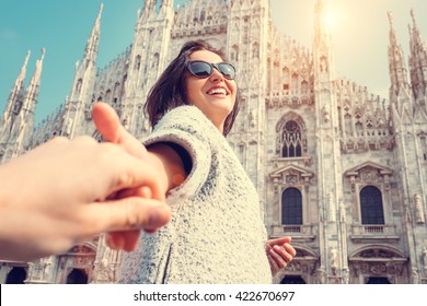 Smiling woman hold her boyfriend hand on Duomo di Milano background - Shutterstock ID 422670697