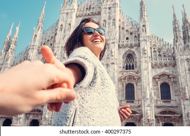 Smiling woman hold his boyfriend hand on Duomo di Milano background - Shutterstock ID 400297375