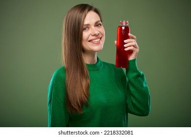 Smiling Woman Holding Bottle With Red Drink. Isolated Advertising Portrait On Green.