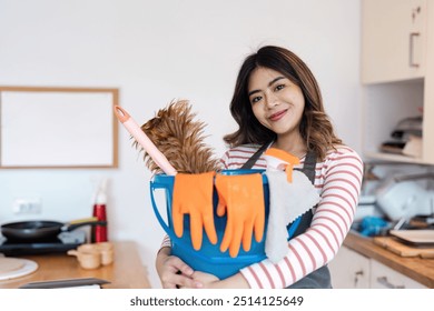 Smiling Woman Holding Cleaning Supplies and Dog in Modern Kitchen, Ready for House Cleaning Service