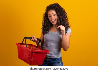 Smiling woman holding empty shopping basket looking at camera smiling - Powered by Shutterstock