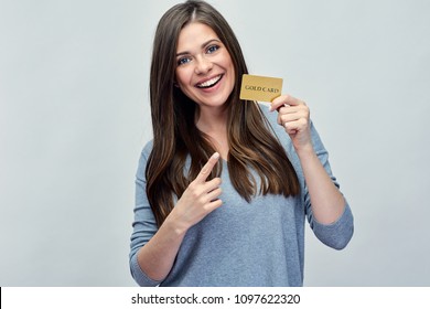 Smiling Woman Holding Gold Credit Card And Pointing Finger. Isolated Portrait Girl With Long Hair.