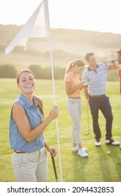 Smiling Woman Holding Golf Flag