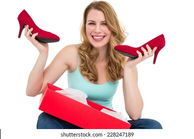 Smiling Woman Holding Up Her New Shoes On White Background