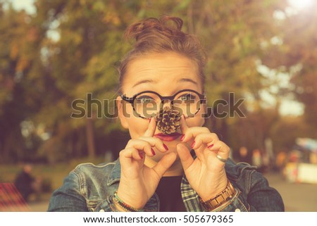 Smiling woman holding pine cone. Autumn concept.

