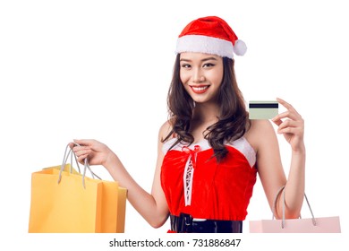 Smiling woman holding shopping bags before christmas showing credit card.