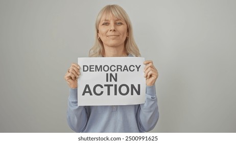 Smiling woman holding a sign that reads 'democracy in action' against a white background. - Powered by Shutterstock