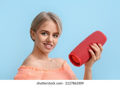 Smiling Woman Holding Wireless Portable Speaker On Blue Background