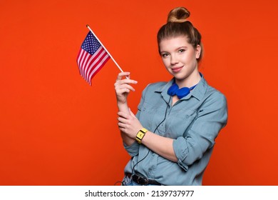 Smiling woman holds small american flag. Female student recommending foreign language studying school. Learning American English, student exchange and travel concept