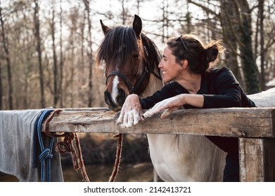 Smiling woman horse owner talks with her pony and showing hands full with animal hair in spring shedding season  - Powered by Shutterstock