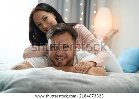 Smiling woman hugging the back of her beloved man