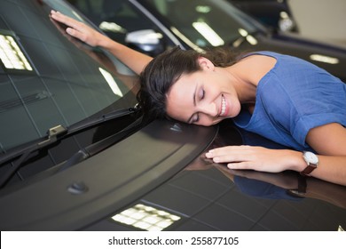 Smiling Woman Hugging A Black Car At New Car Showroom