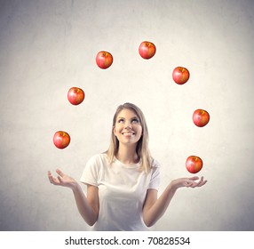 Smiling woman juggling with apples