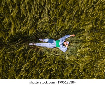 Smiling Woman Laying Down In Wheat Field Overhead Top View