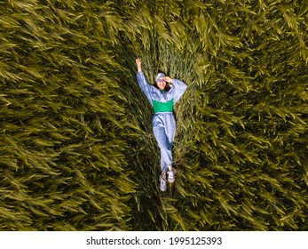 Smiling Woman Laying Down In Wheat Field Overhead Top View