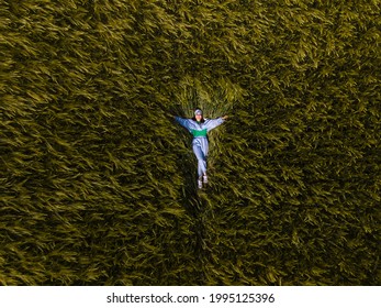 Smiling Woman Laying Down In Wheat Field Overhead Top View