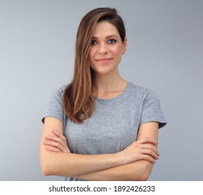 Smiling woman with long hair standing with crossed arms. isolated female studio portrait.