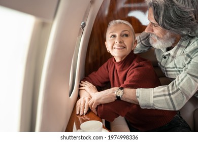 Smiling woman looking at husband in private jet
