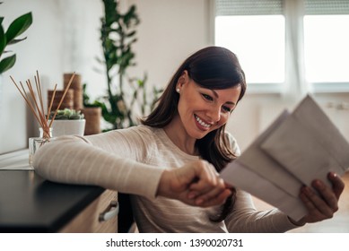 Smiling Woman Looking At Received Mail At Home, Close-up.