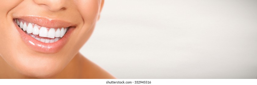 Smiling woman mouth with great teeth. Over gray background