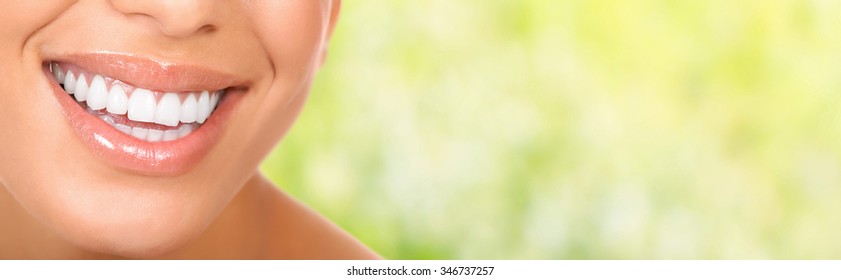 Smiling woman mouth with great teeth. Over green background
