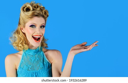 Smiling woman with open hand palm with copy space for product or text. Female model with bright makeup, retro hairdo.