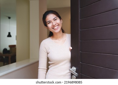 smiling woman opening the door welcome to the house - Powered by Shutterstock