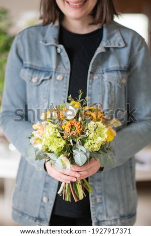 Smiling woman with orange yellow flower bouquet