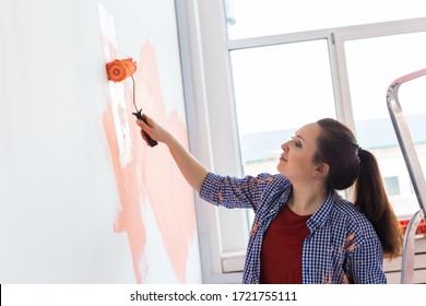 Smiling Woman Painting Interior Wall Of Home. Renovation, Repair And Redecoration Concept.