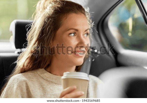 smiling woman
or passenger drinking coffee in
car