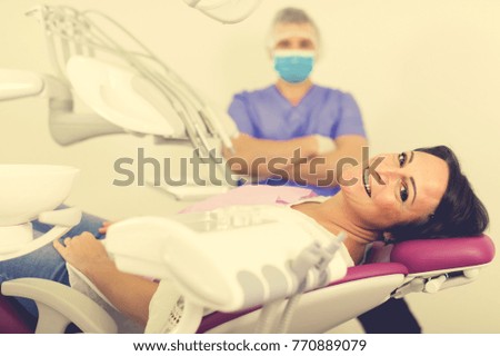 smiling woman patient with dentist professional sitting in medical room