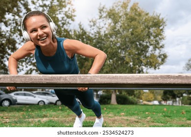 Smiling woman performing push-ups on a bench during outdoor workout. - Powered by Shutterstock