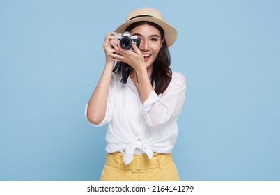 smiling Woman photographer is taking images photo with dslr camera isolated studio blue background.