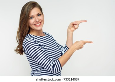 Smiling woman pointing finger side. Isolated portrait on white.