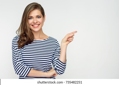 Smiling woman pointing finger side. Isolated portrait on white.