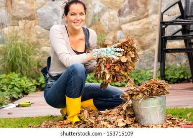 Smiling Woman Putting Leaves In Bucket Fall Garden Housework